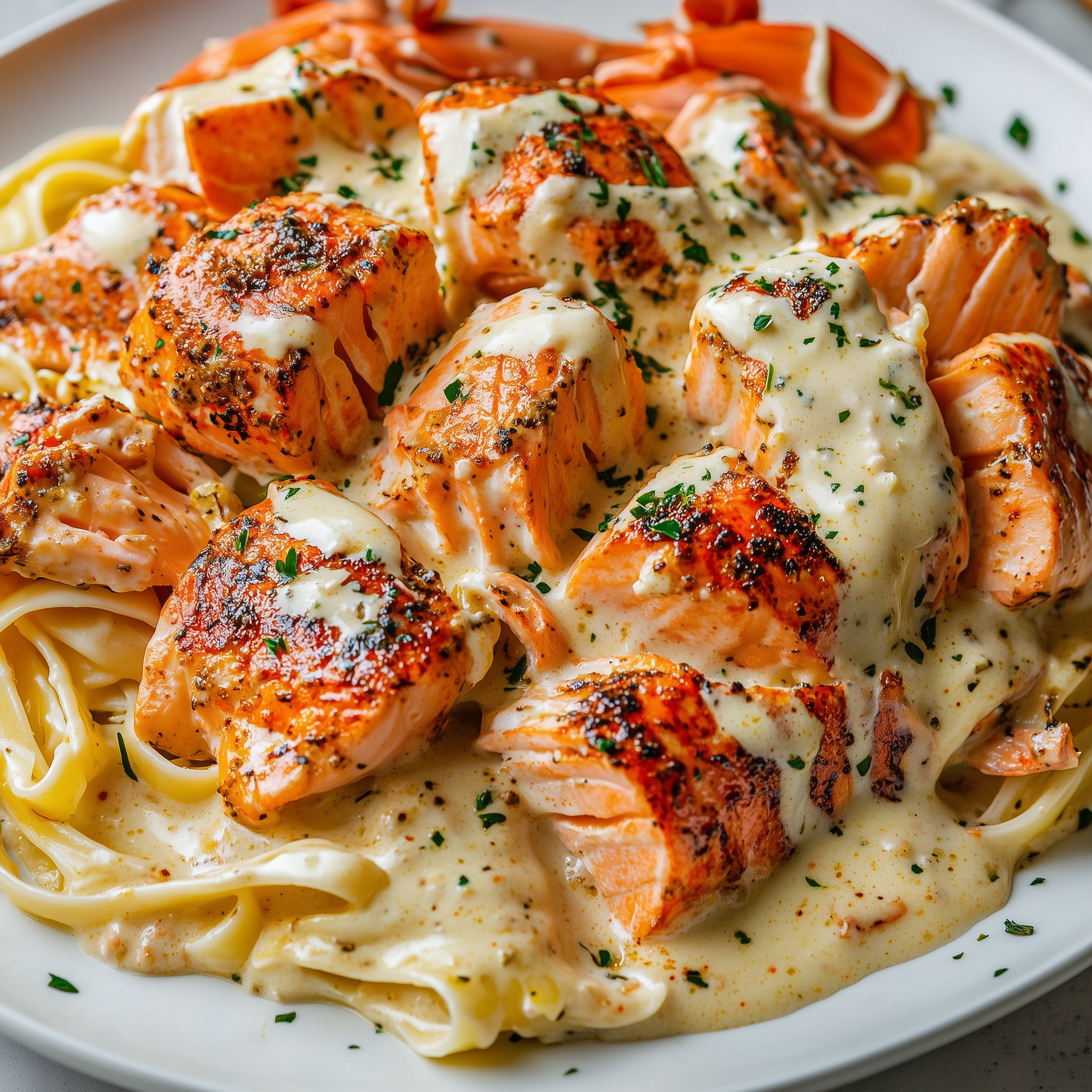 Cajun lobster and salmon Alfredo pasta with parsley garnish